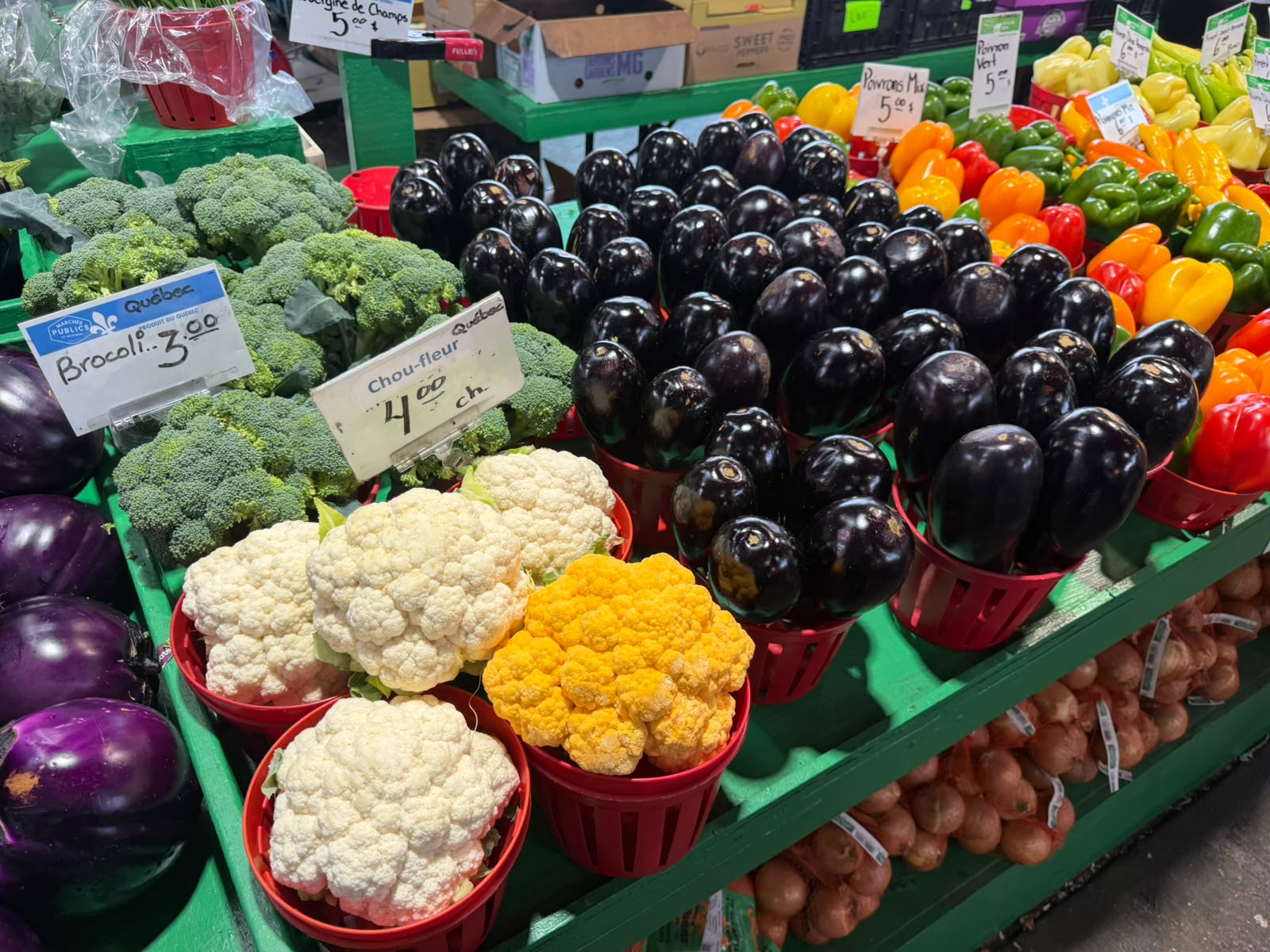 Bancas de brócolis, couve-flor e berinjela no Marché Jean-Talon, com selo de produto de Quebec